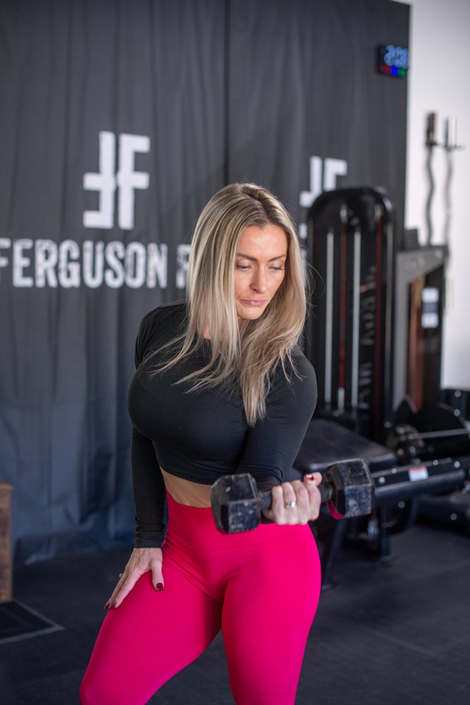 The coach is holding the dumbelle.